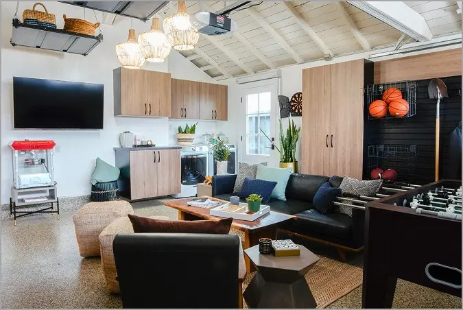 Updated garage with wooden storage cabinet, beige epoxy floor, and converted into a living room