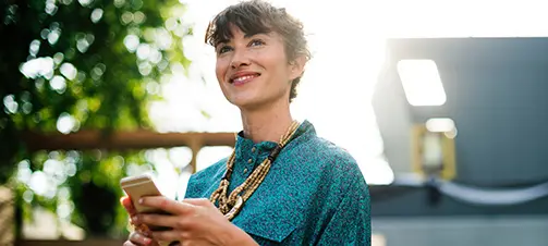 woman smiling and holding a phone in her hands