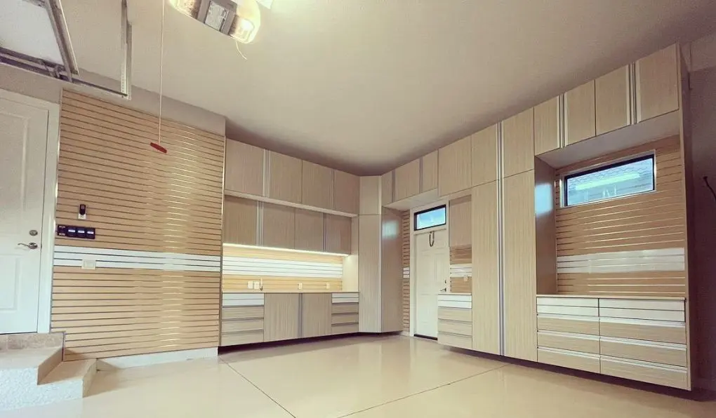 Light beige wooden garage storage system with beige epoxy flooring